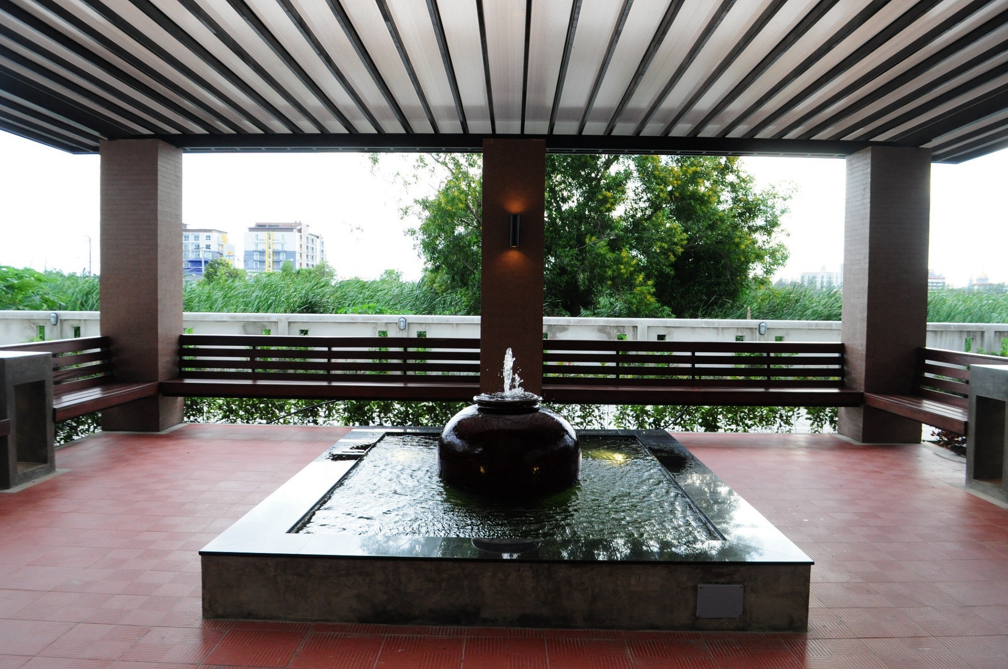 Open-air relaxing area with a water feature and greenery