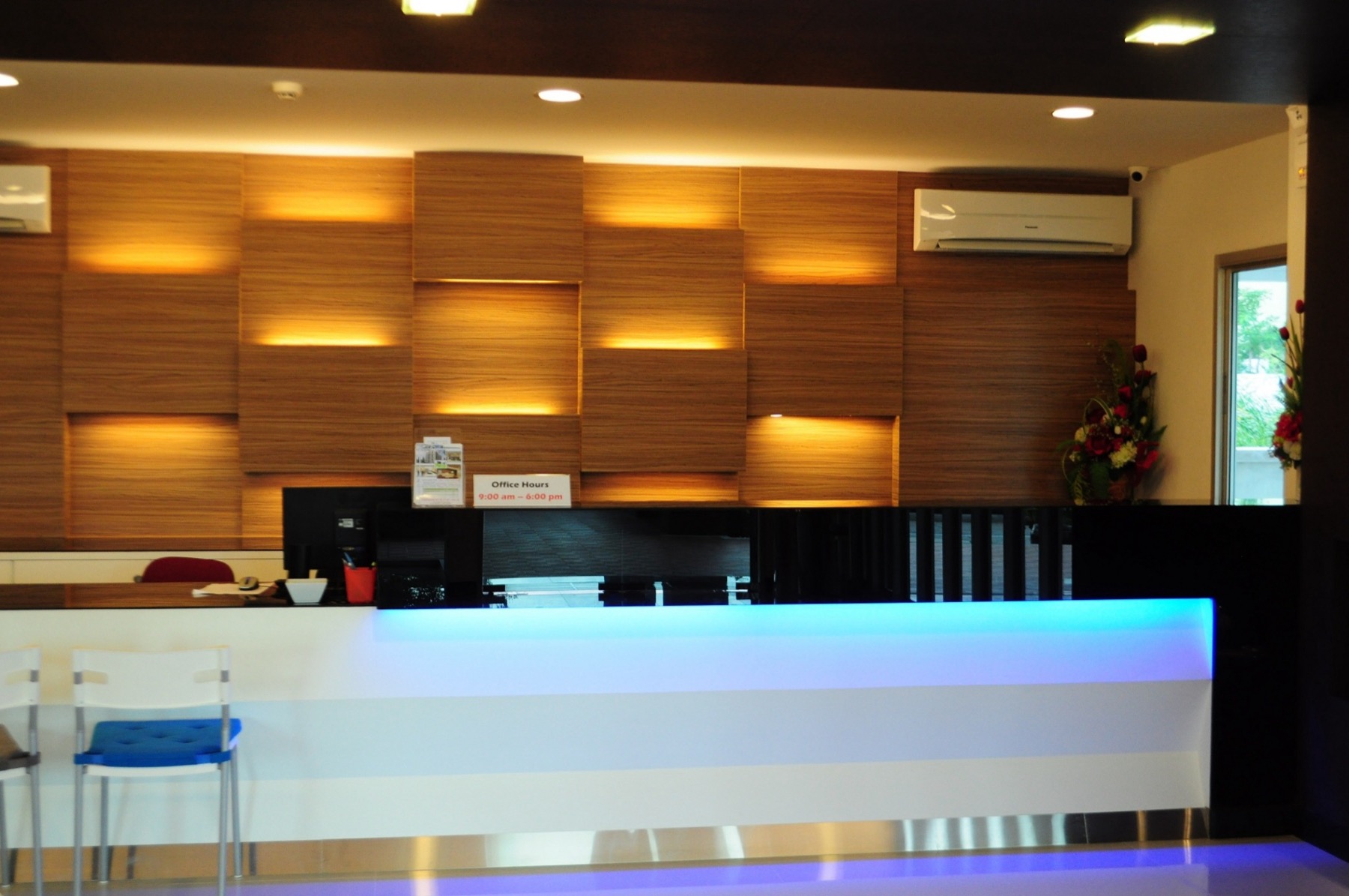 Lobby reception counter with a wood feature wall and ambient lighting