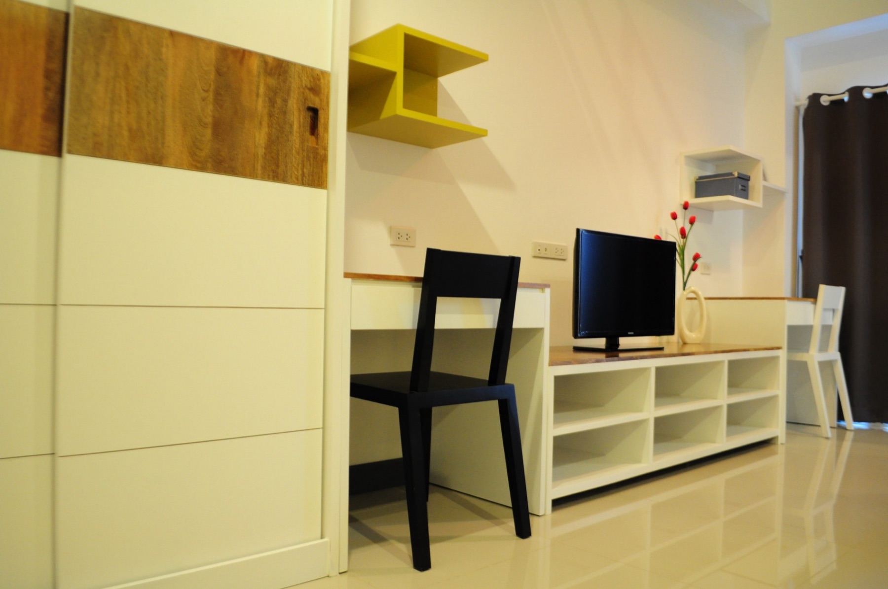 Workspace, television, and storage inside the Loft room
